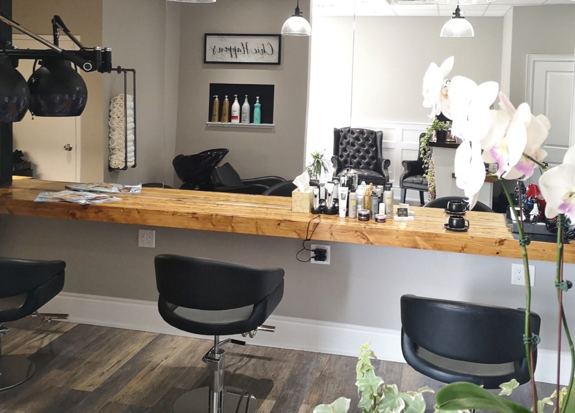 Modern salon interior at Hair Studio Midland in Midland, Ontario, CA with chic chairs and wooden styling counter.