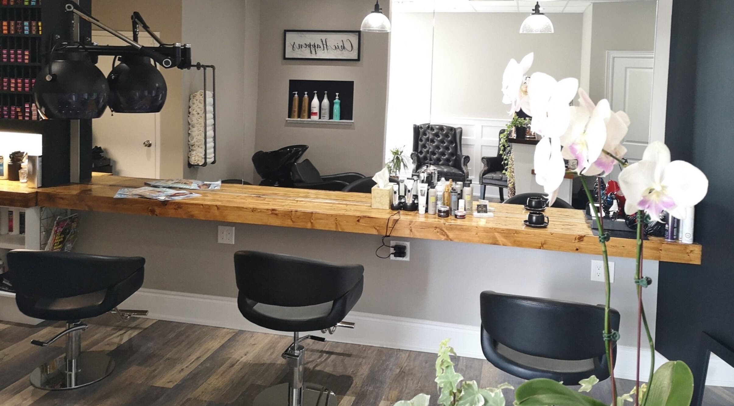 Modern salon interior at Hair Studio Midland in Midland, Ontario, CA with chic chairs and wooden styling counter.