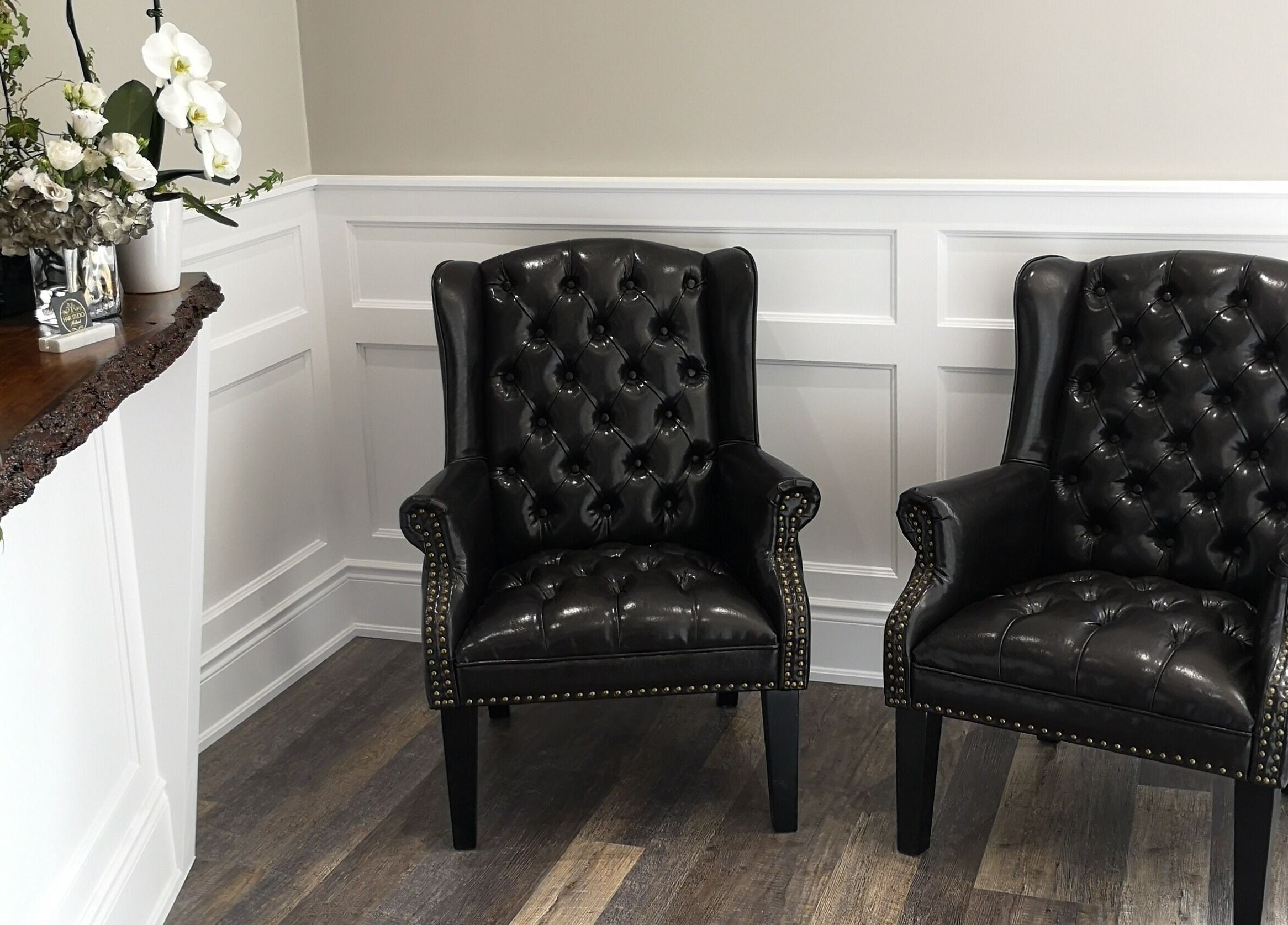 Luxurious seating area in Hair Studio Midland featuring black leather chairs. Midland, Ontario, CA.