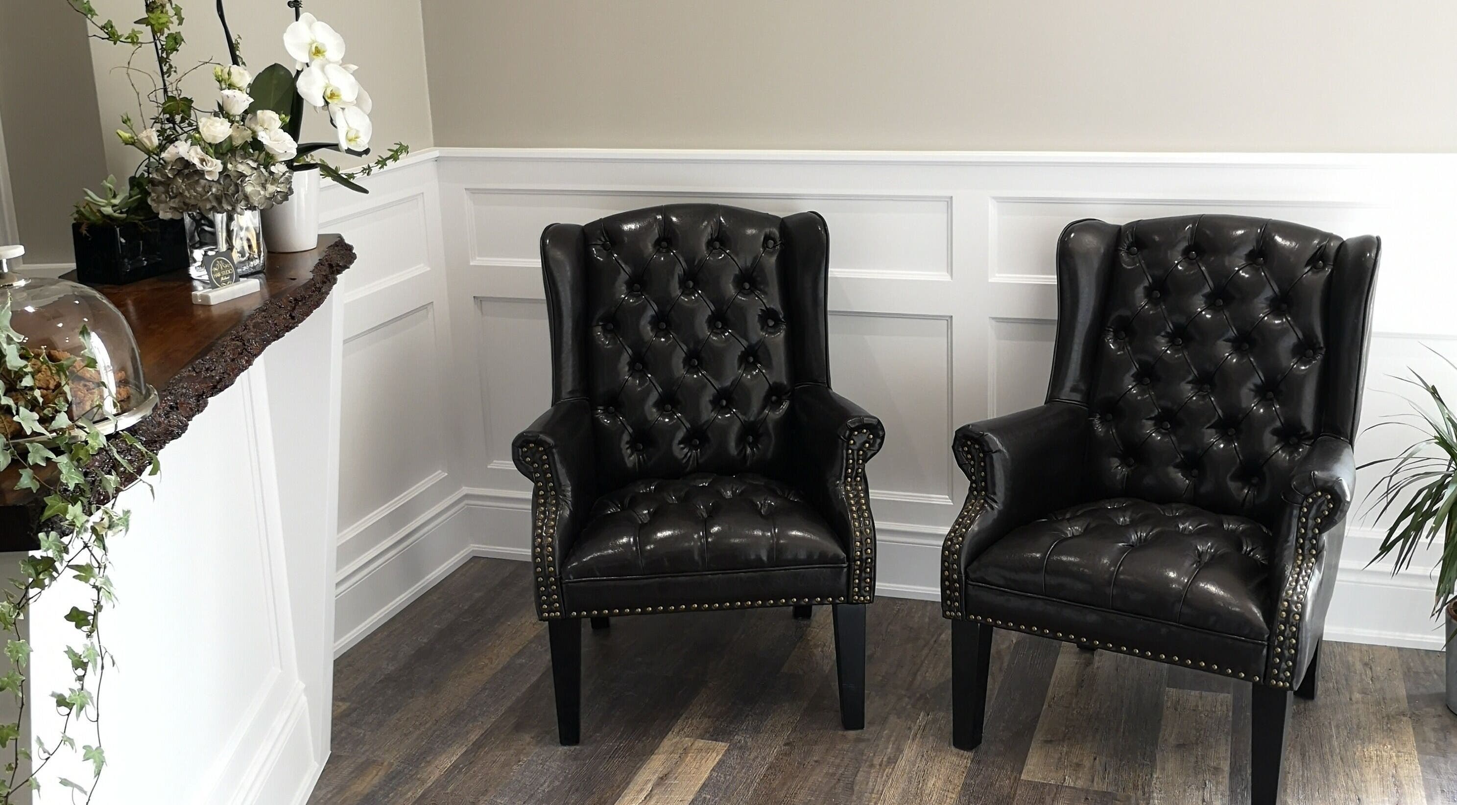 Luxurious seating area in Hair Studio Midland featuring black leather chairs. Midland, Ontario, CA.