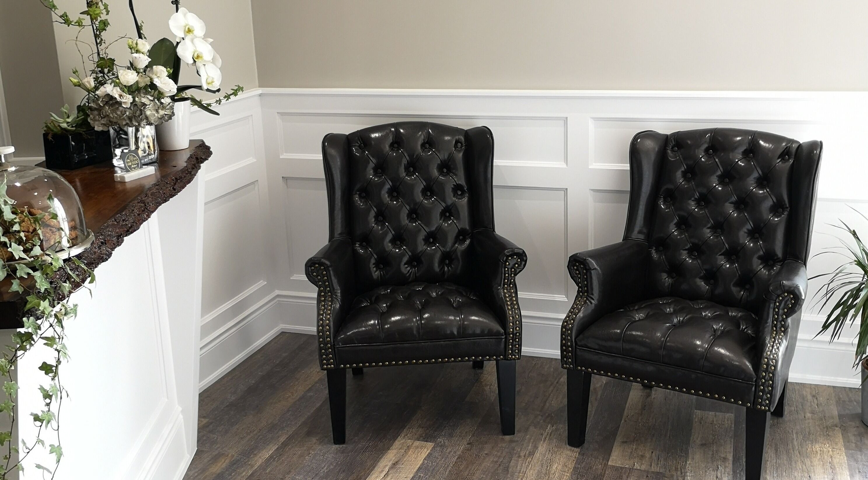 Luxurious seating area in Hair Studio Midland featuring black leather chairs. Midland, Ontario, CA.