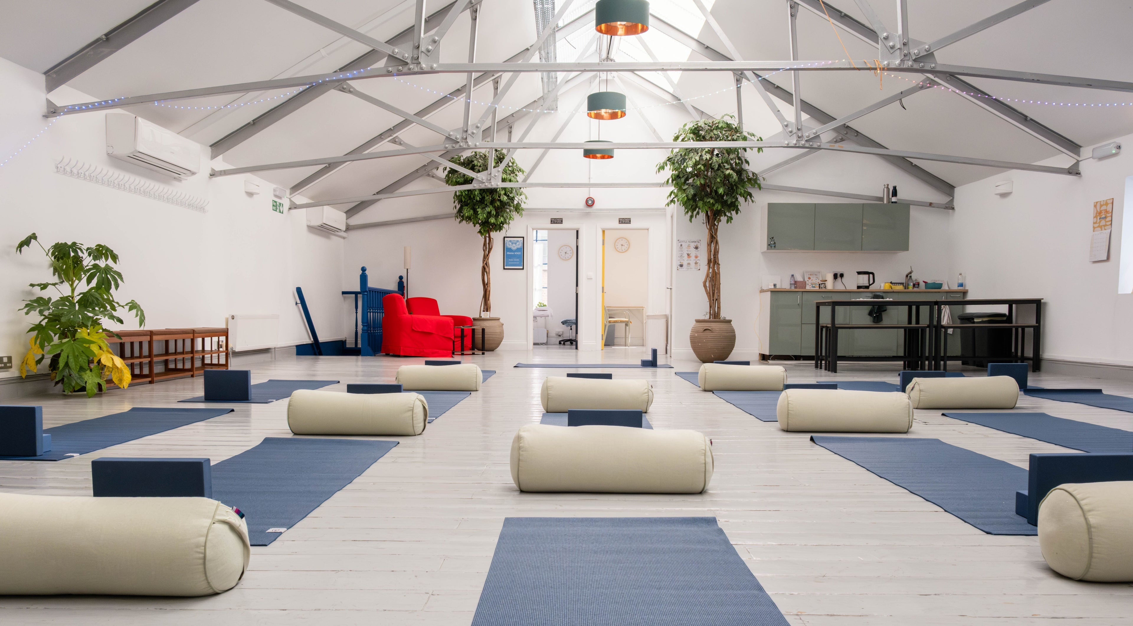 Spacious yoga room at Prana Voice, London, England, GB with mats and bolsters for serene wellness sessions.