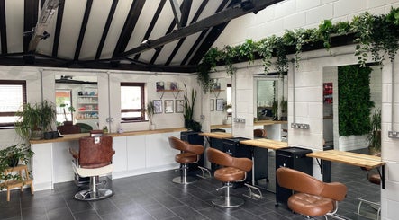 Seacombe & Co. salon interior in Chichester, England featuring sleek chairs and greenery.