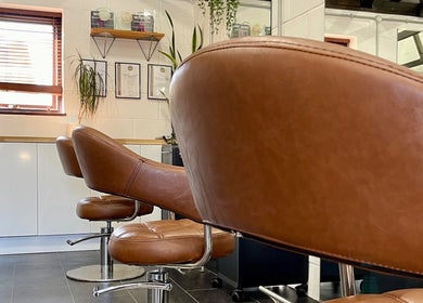 Modern salon chairs at Seacombe & Co., Chichester, England, GB featuring sleek design and elegance.