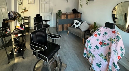 Stylish interior of No. 14 Barbershop in Plymouth, England, GB, featuring modern black chairs and a cozy reception.