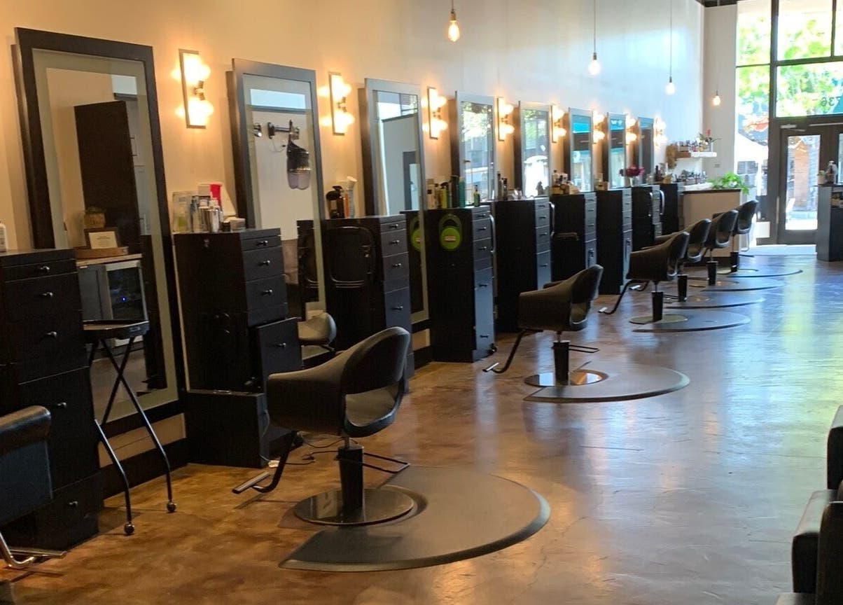Sleek interior of Adriana at Salon Vivo, showcasing styling chairs and mirrors in San Carlos, California, US.