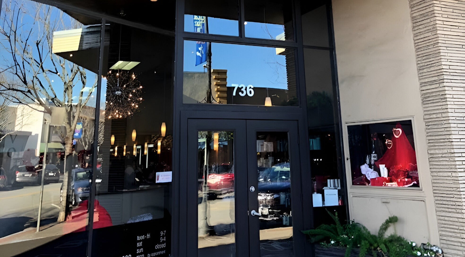 Entrance of Adriana at Salon Vivo in San Carlos, California, US, showcasing modern glass doors and stylish decor.