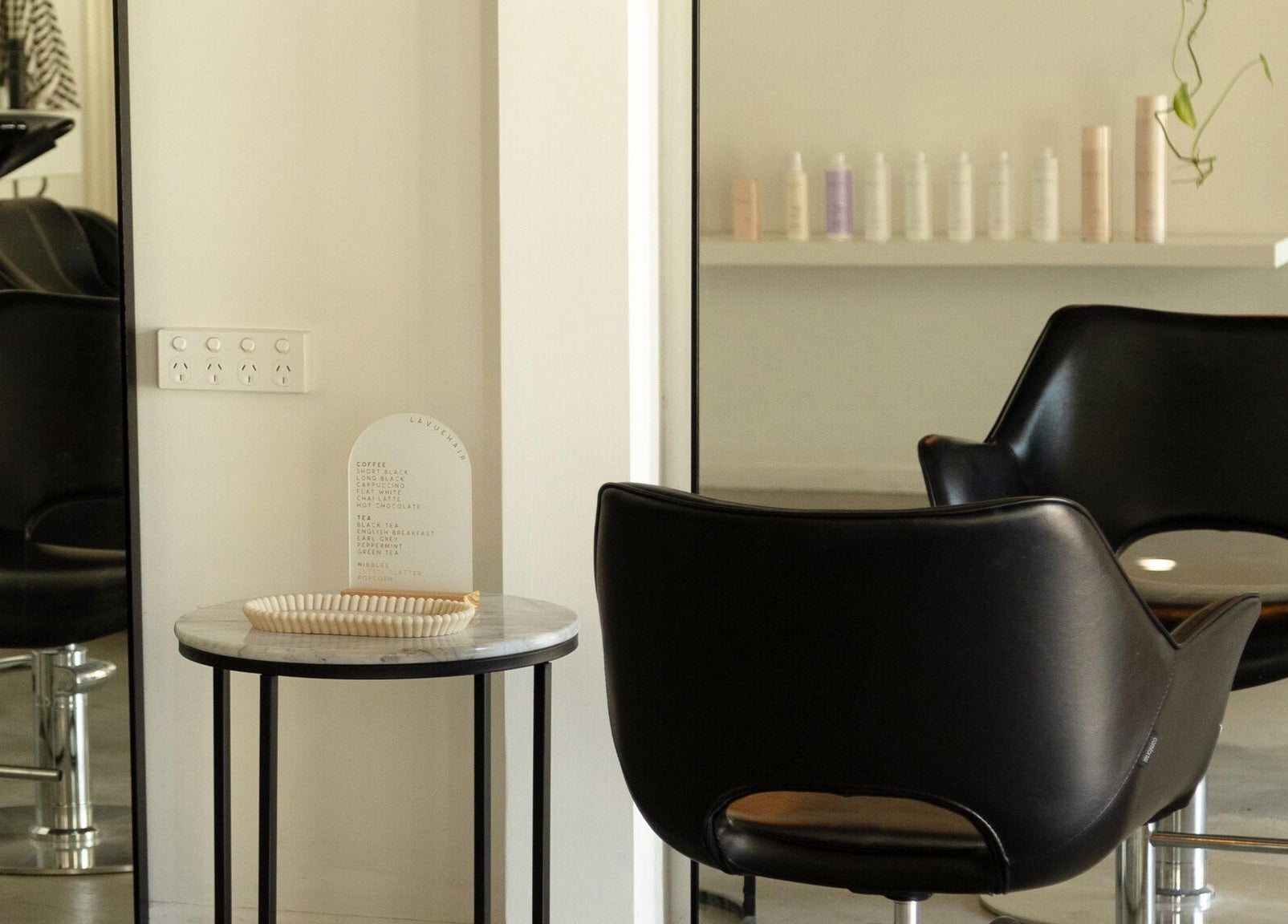 Sleek black salon chairs and a table at Lávue Hair, Wavell Heights, Queensland, AU, showcasing modern style.