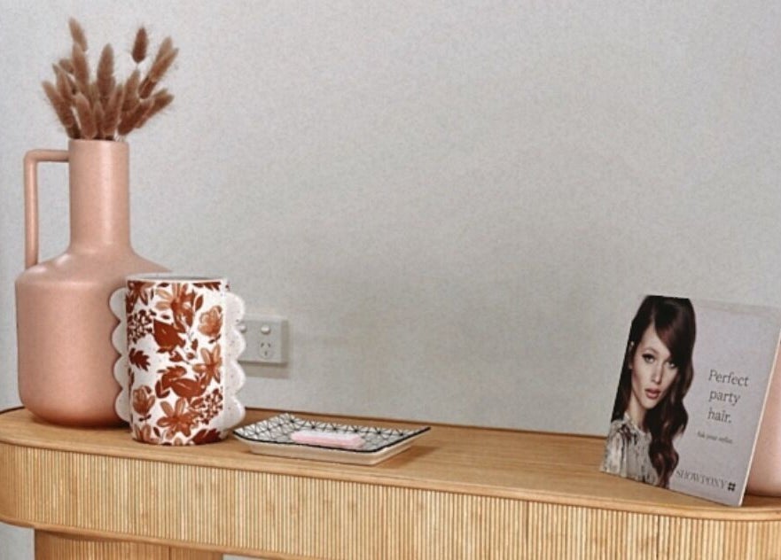 Elegant shelf with decor at Lávue Hair, Wavell Heights, Queensland, AU. Features chic vase and floral cup.