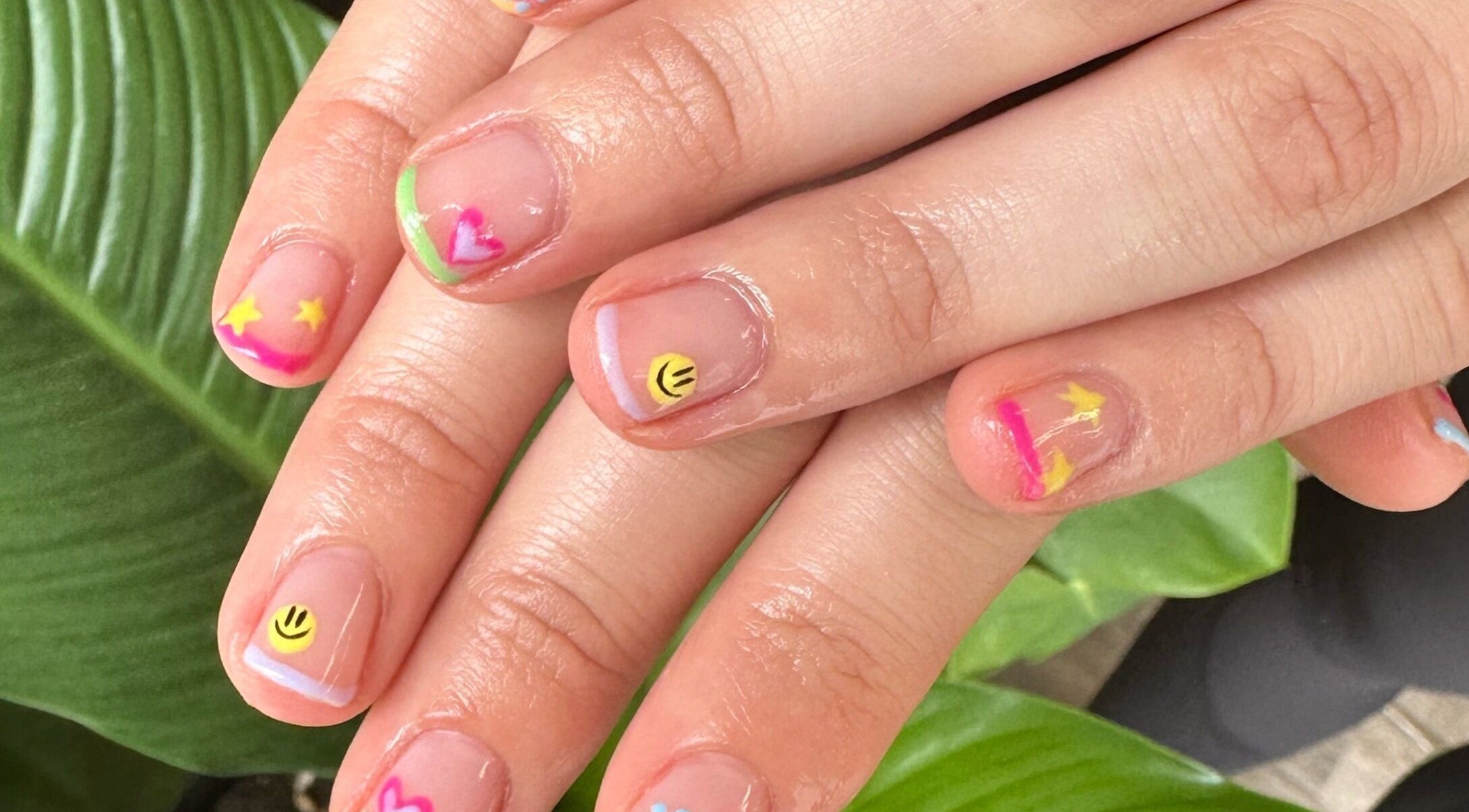 Colorful nail art with smiley and stars at Red Desert Beauty, Uleybury, South Australia, AU.