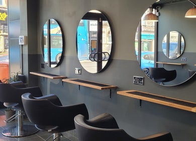 Sleek styling area at Gareth at Artistic Hair Co, Bristol, England, GB, featuring modern chairs and mirrors.