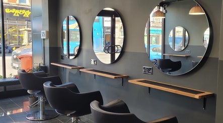Sleek styling area at Gareth at Artistic Hair Co, Bristol, England, GB, featuring modern chairs and mirrors.
