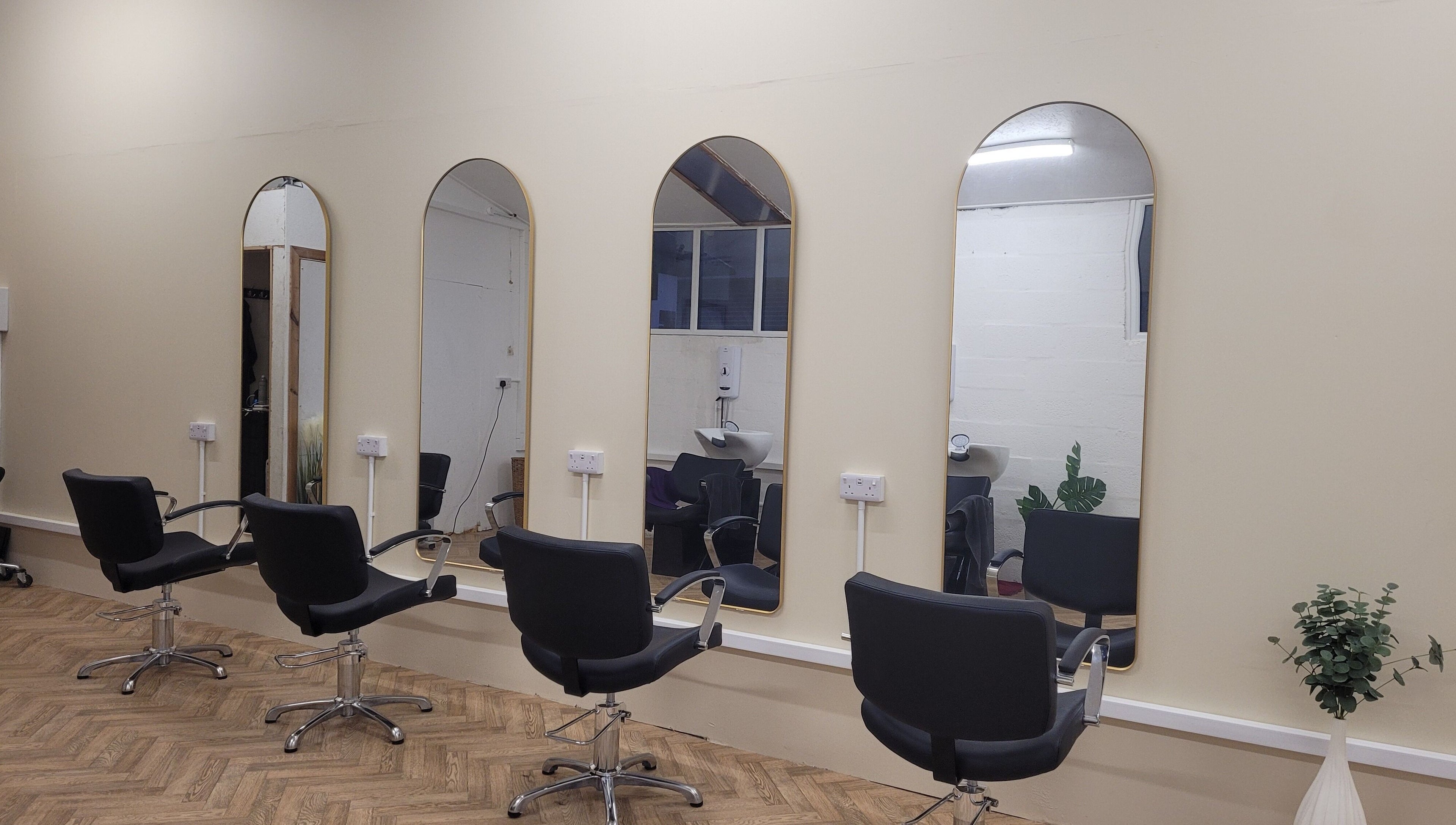Stylish interior of Gareth at The Loft Hair Studio in Bristol, England, GB with chic mirrors and chairs.
