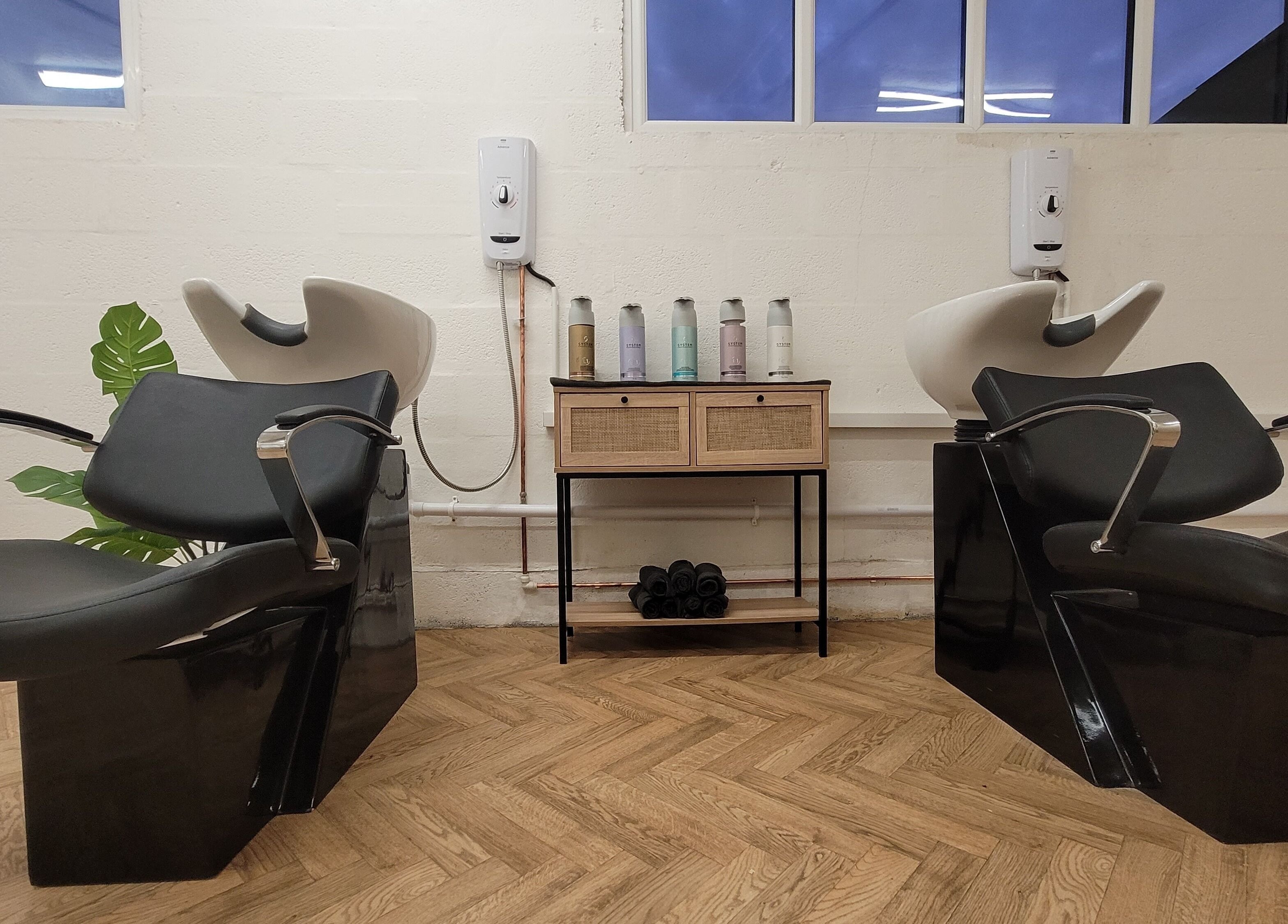 Elegant wash stations at Gareth at The Loft Hair Studio, Bristol, England, GB with sleek black chairs.
