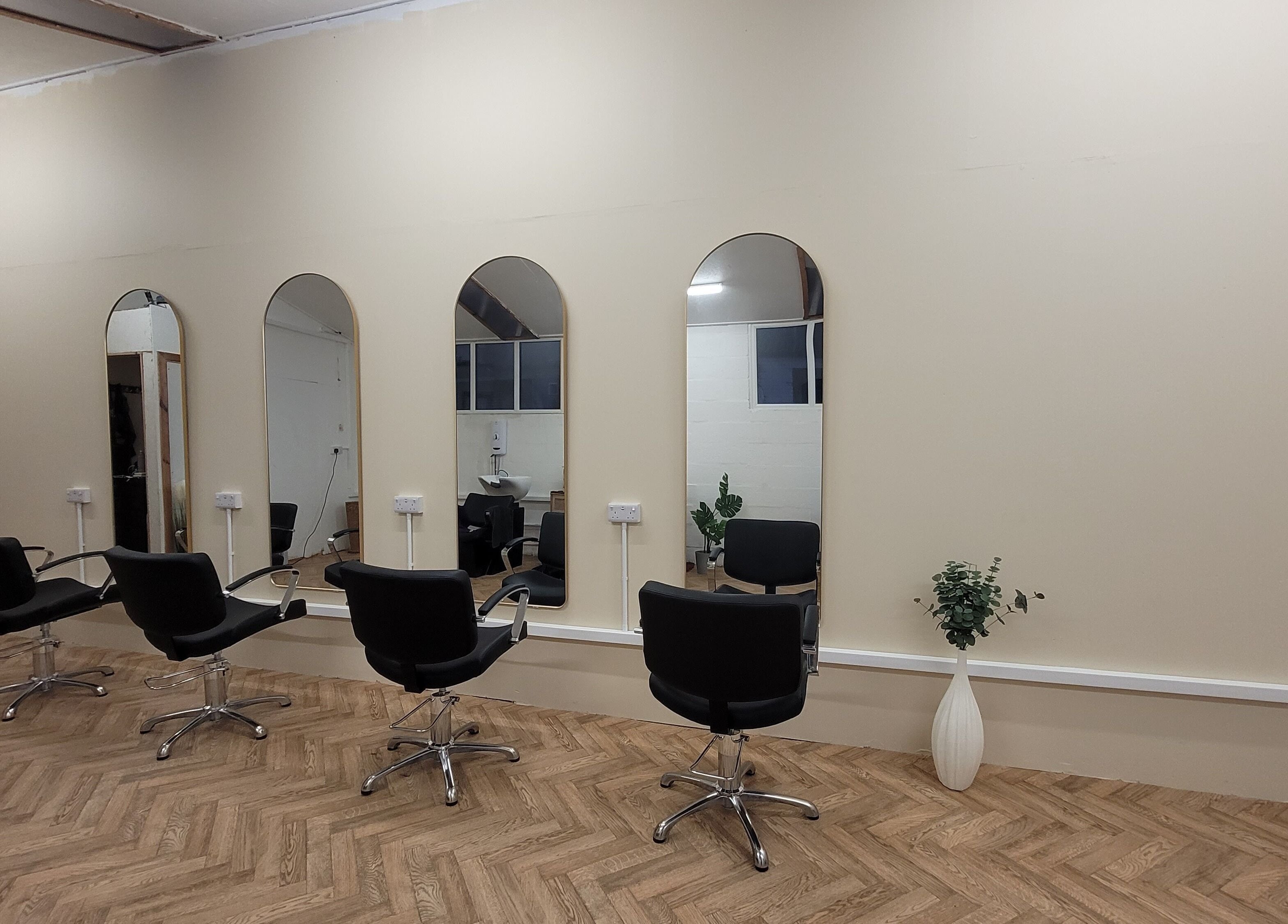 Elegant salon interior at Gareth at The Loft Hair Studio, Bristol, England, GB with wall mirrors and styling chairs.