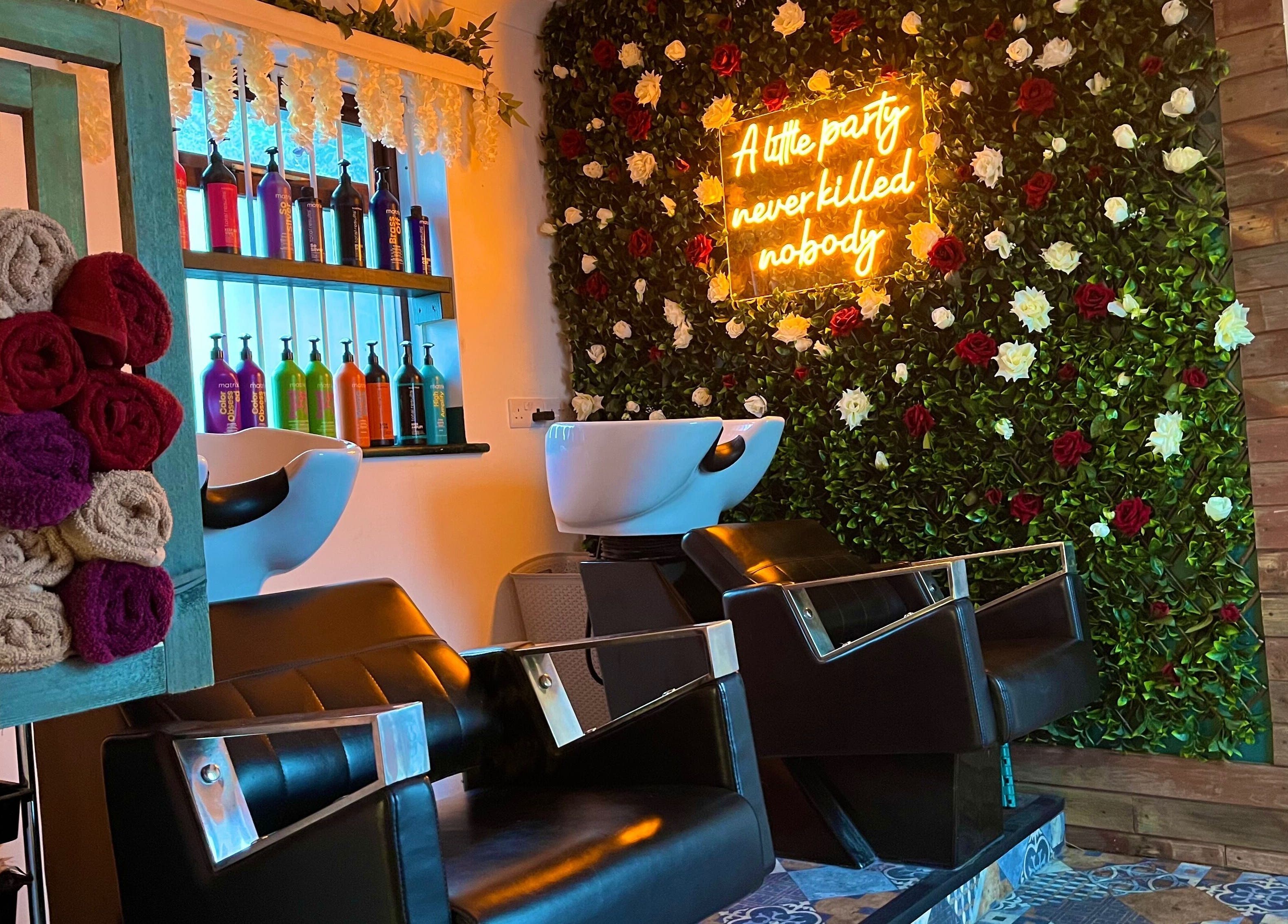 Stylish salon interior at Redlocks Hair, Bournemouth, England. Vibrant colors and floral decor create a chic atmosphere.