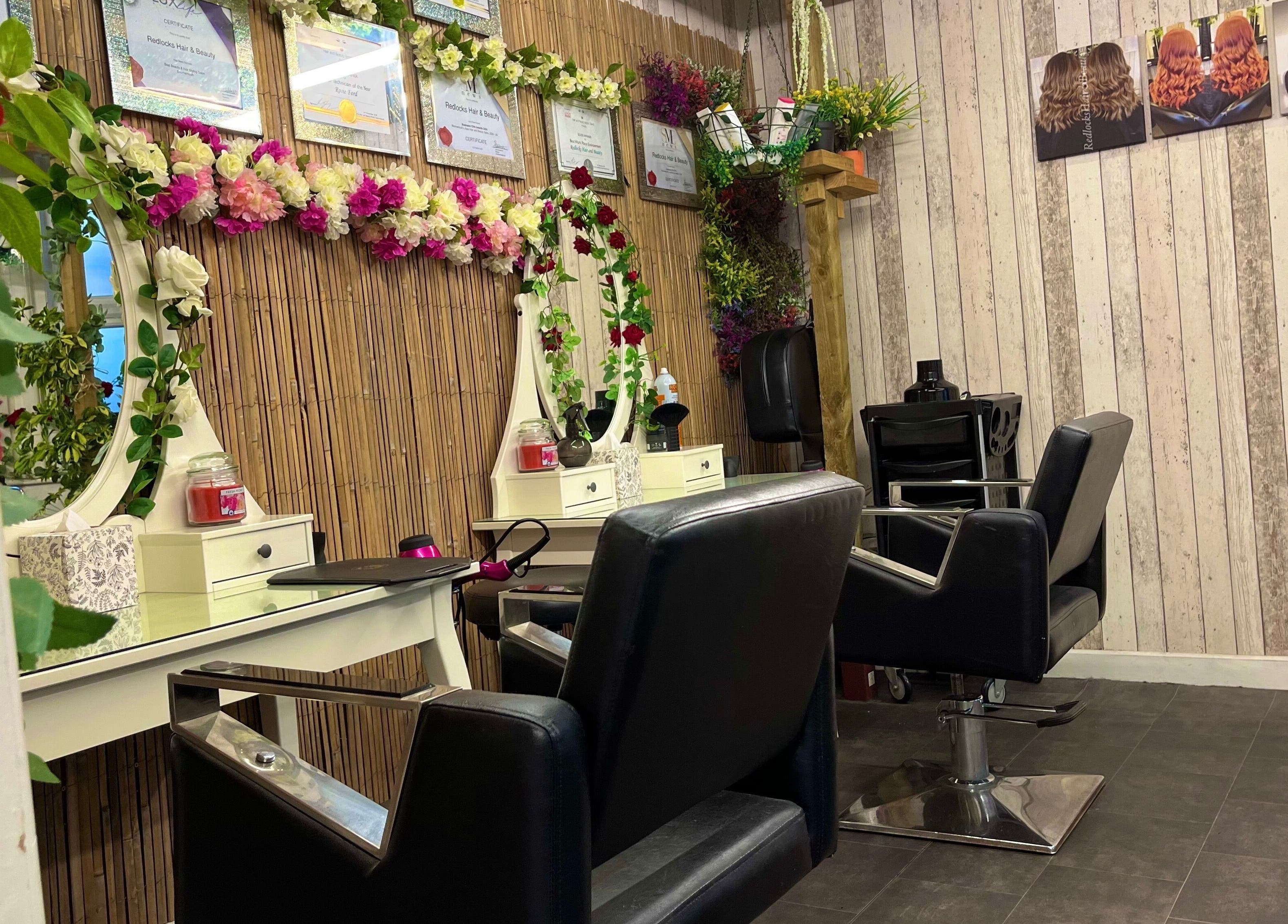 Elegant styling chairs and floral mirror at Redlocks Hair, Bournemouth, England, GB.