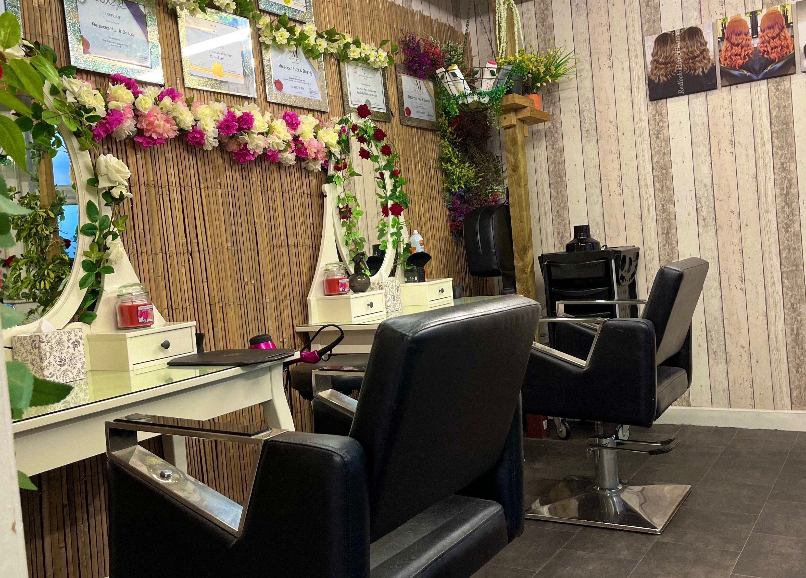Elegant styling chairs and floral mirror at Redlocks Hair, Bournemouth, England, GB.