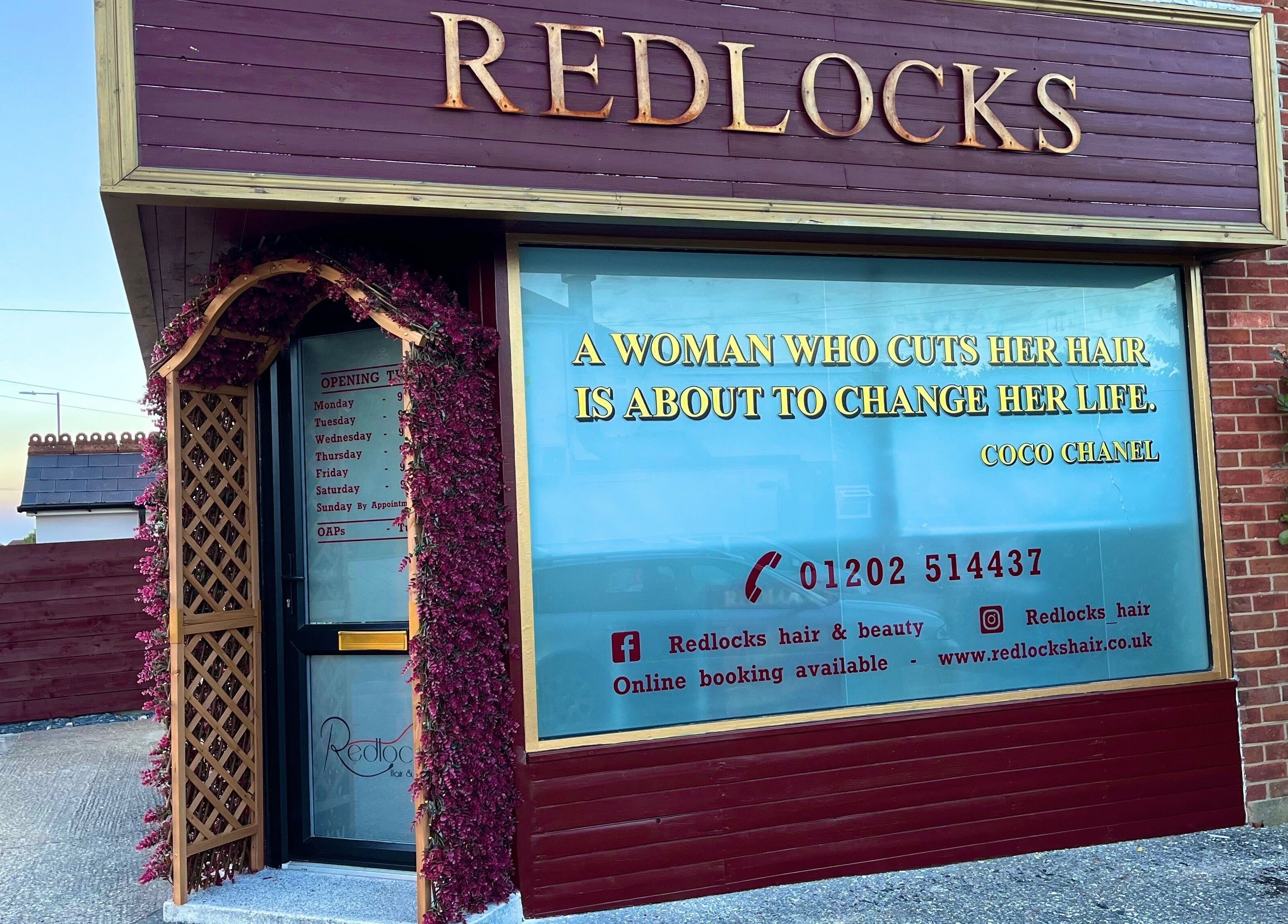 Exterior of Redlocks Hair in Bournemouth, England, GB, featuring elegant signage and floral accents.