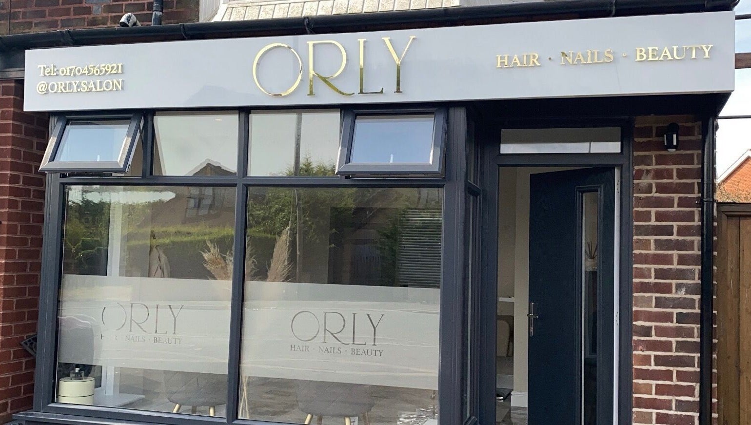 Front exterior of Orly salon in Southport, England, GB showcasing its elegant signage and large windows.