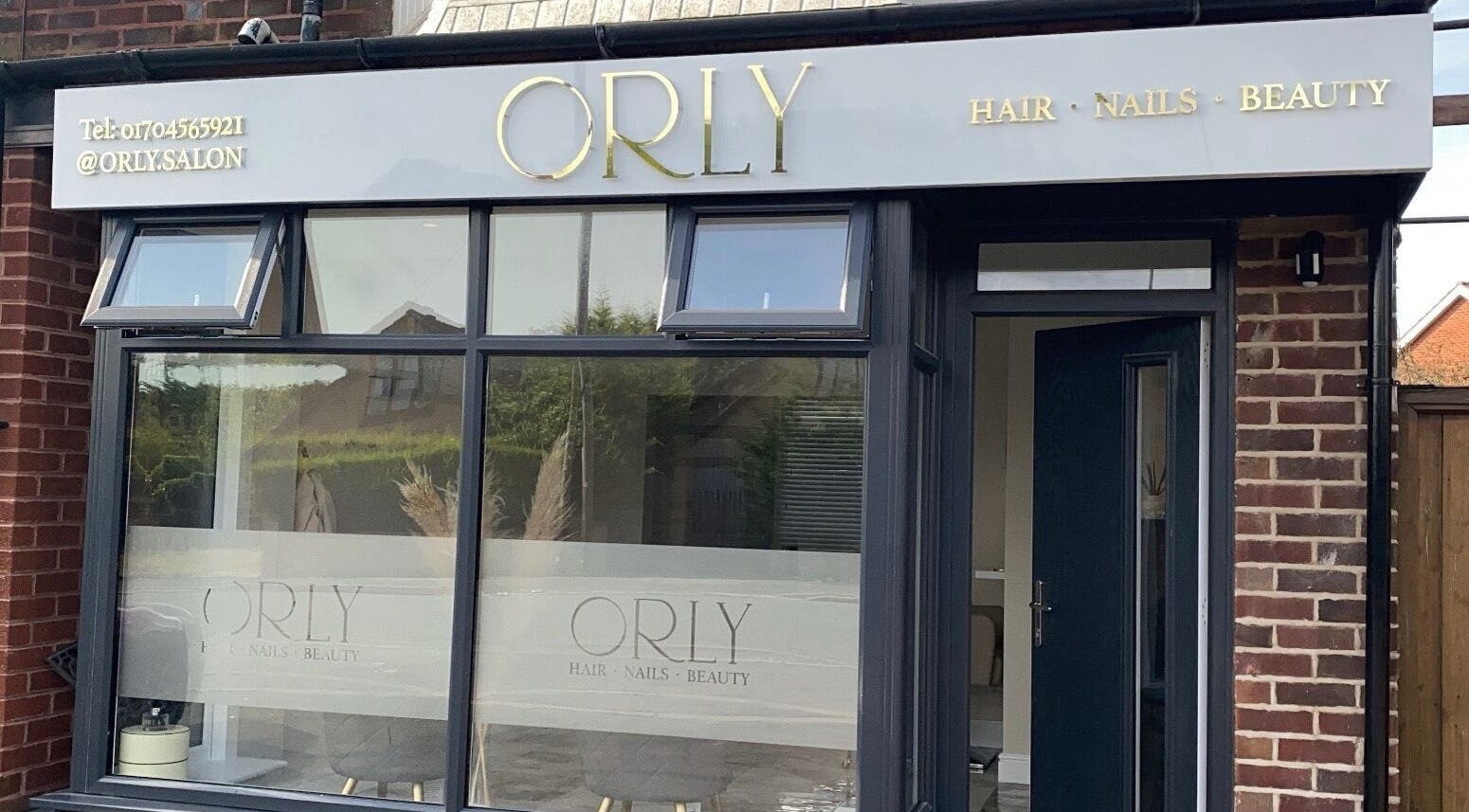 Front exterior of Orly salon in Southport, England, GB showcasing its elegant signage and large windows.