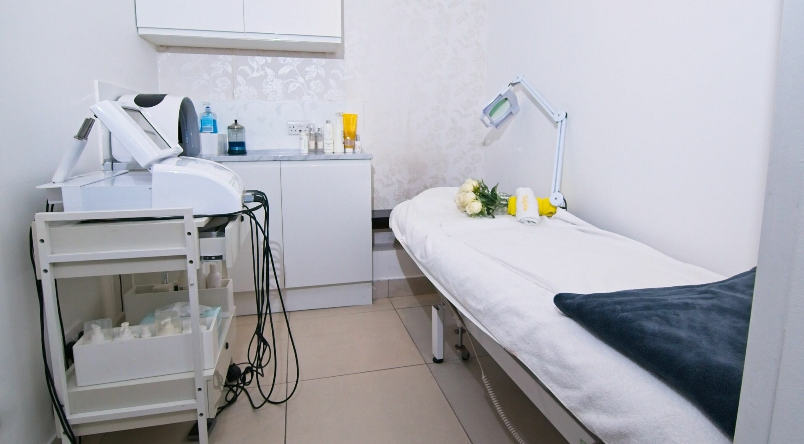 Treatment room at Sajna Hair & Beauty, Wimbledon, London, England, GB featuring a cozy bed and modern equipment.