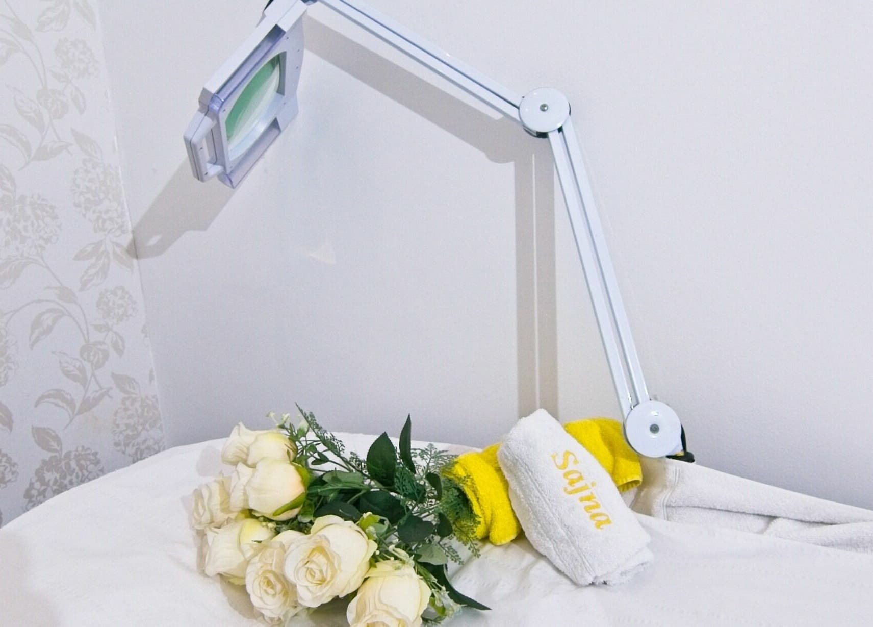 Relaxing treatment room at Sajna Hair & Beauty, Wimbledon in London, England, GB with flowers and towel.