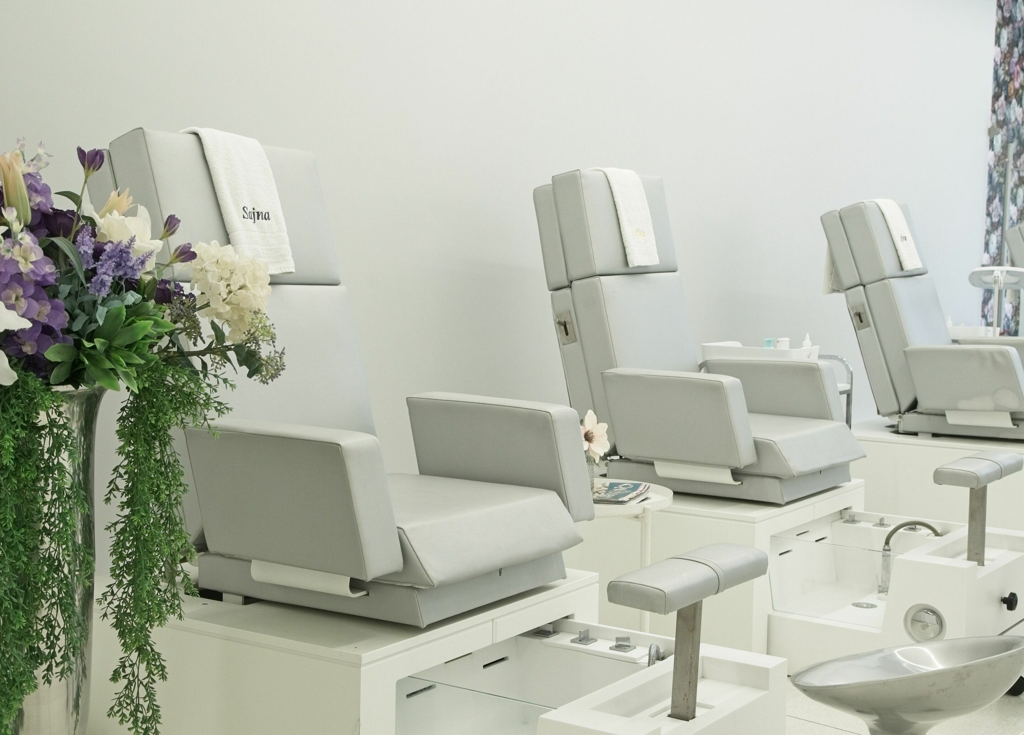 Elegant pedicure chairs at Sajna Hand & Foot Spa, Wimbledon, London, England, GB adorned with fresh flowers.