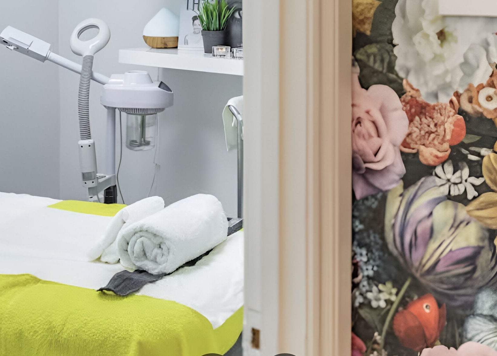Therapy room with floral wall at Sajna Beauty Spa Clapham, London, England, GB, featuring a spa bed.