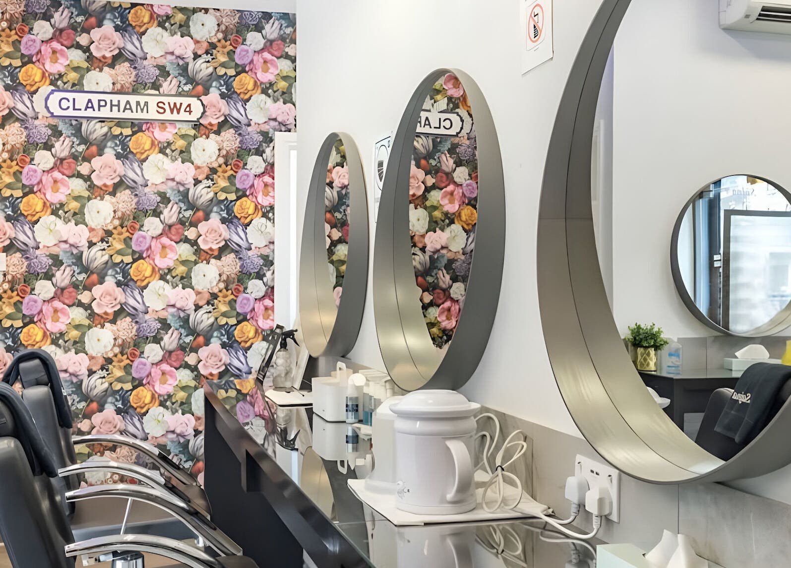 Interior of Sajna Beauty Spa Clapham in London, England, GB with floral wall and sleek mirrors.