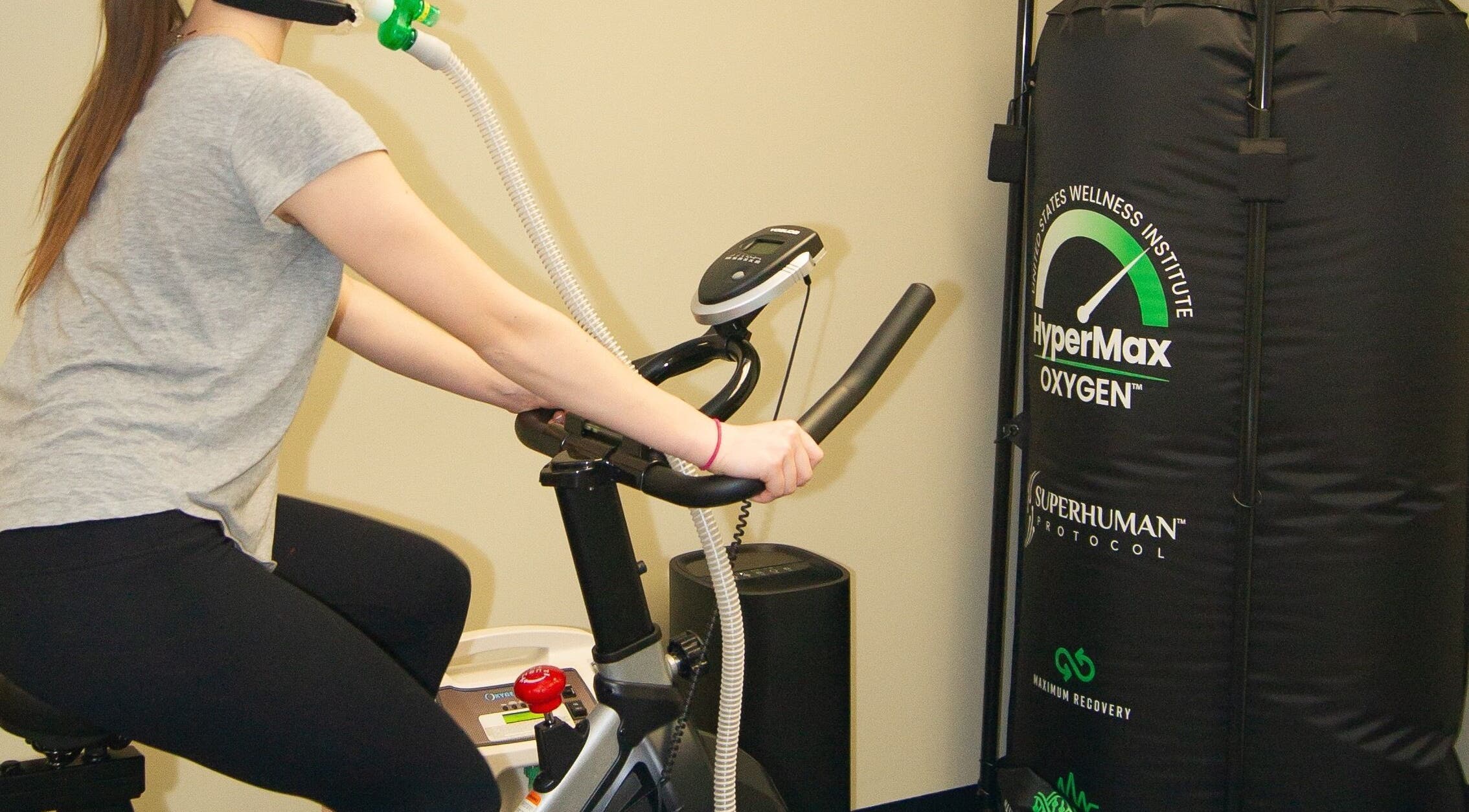 A person exercises on a bike with HyperMax mask at Alfred's Wellness, Willowbrook, Illinois, US.