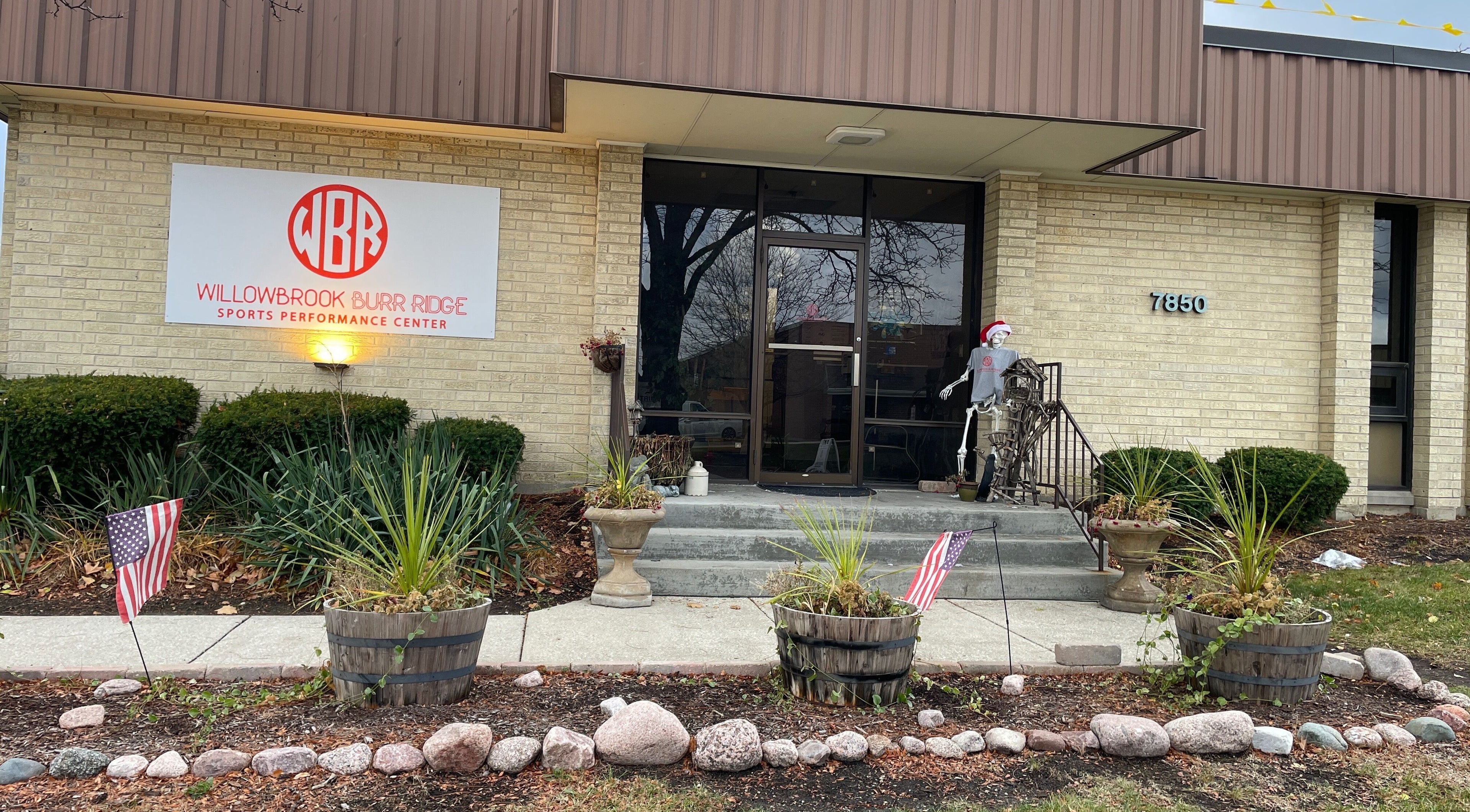 Entrance to Alfred's Wellness in Willowbrook, Illinois, US with festive decorations and green plants.