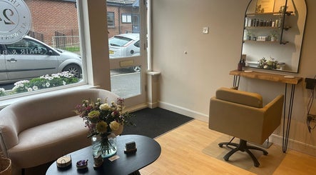 Cozy seating area at The Salon At Twenty Four, Woodford Halse, England, GB, with fresh flowers and a styling chair.