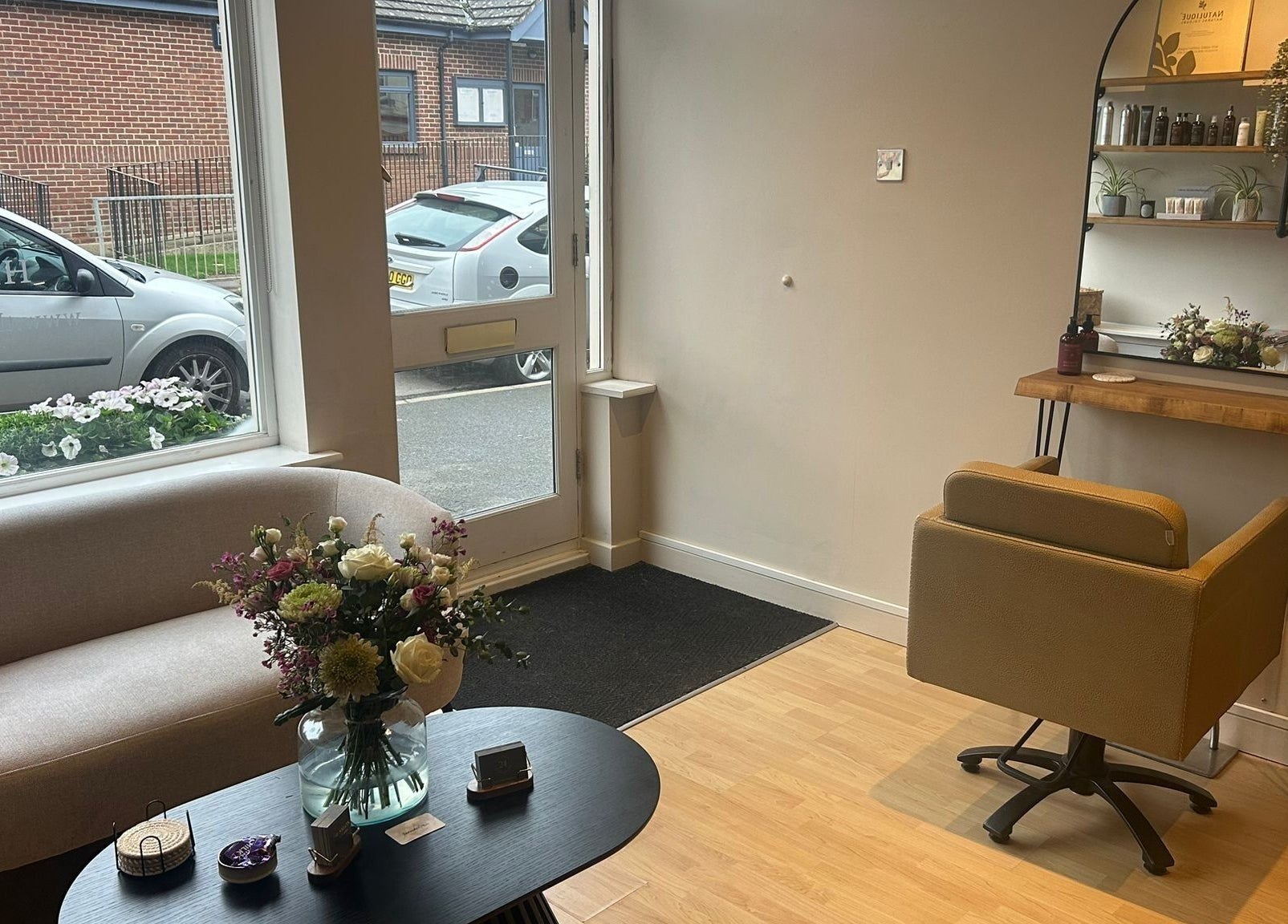 Chic interior of The Salon At Twenty Four in Woodford Halse, England, featuring modern seating and floral decor.