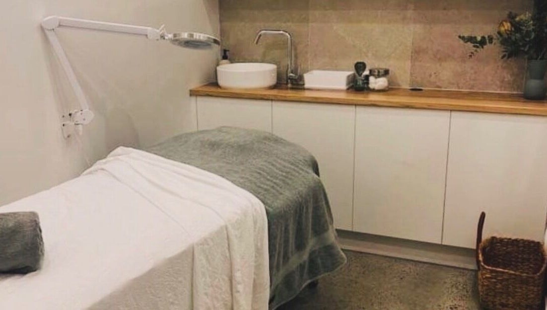 Relaxing treatment room at Aqua Beauty Bar, Melbourne, Victoria, AU, featuring a plush treatment bed and warm decor.