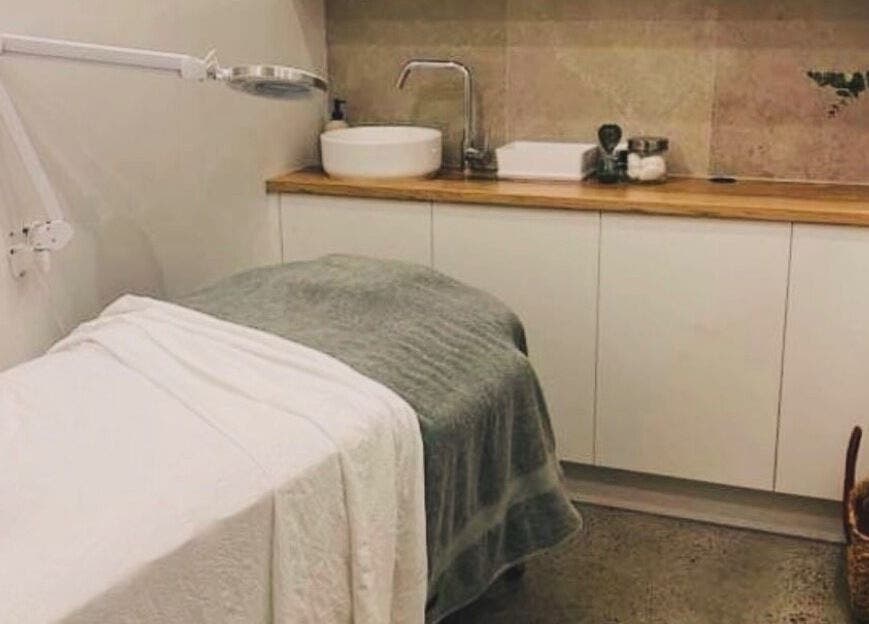 Relaxing treatment room at Aqua Beauty Bar, Melbourne, Victoria, AU, featuring a plush treatment bed and warm decor.