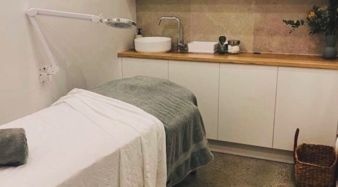 Relaxing treatment room at Aqua Beauty Bar, Melbourne, Victoria, AU, featuring a plush treatment bed and warm decor.