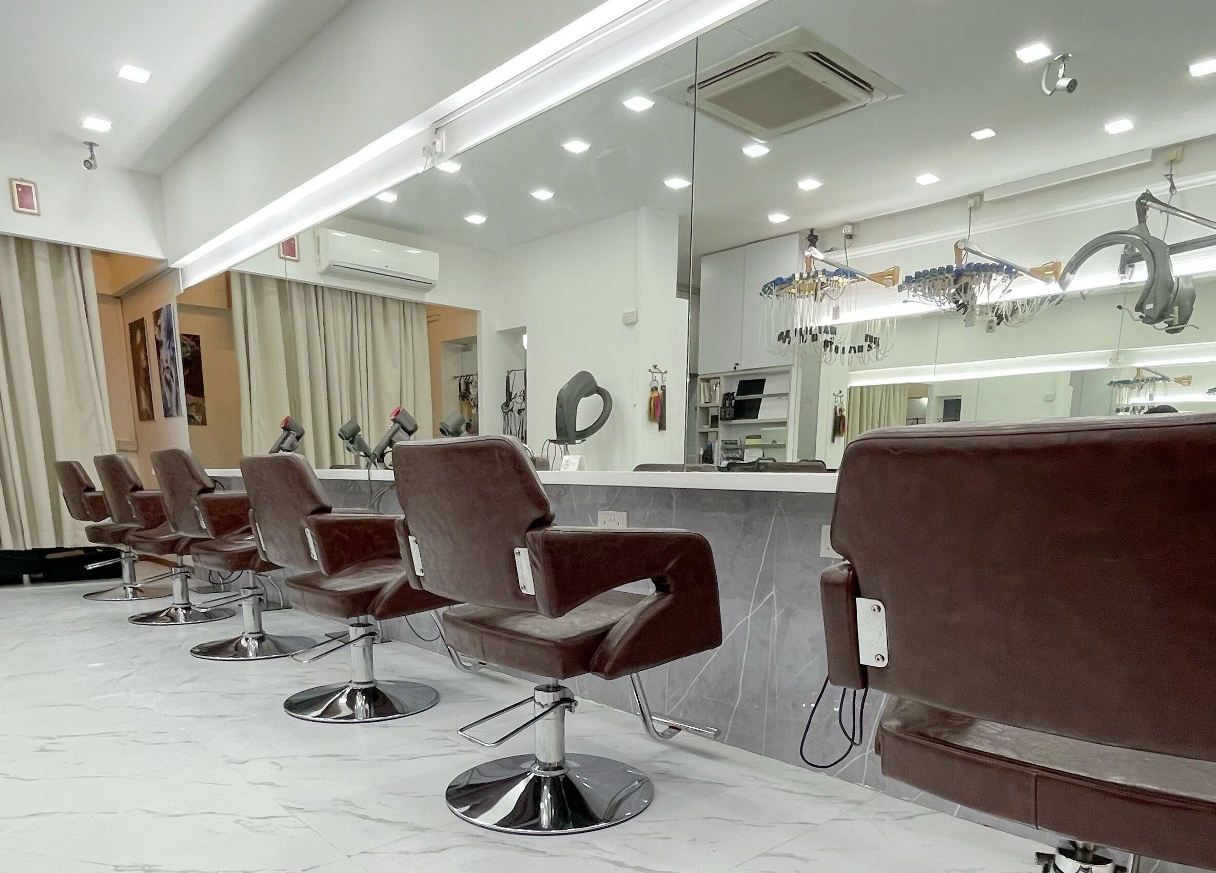 Modern interior of HAVA Hair with chic brown salon chairs in Complex, SG, reflecting luxury and style.