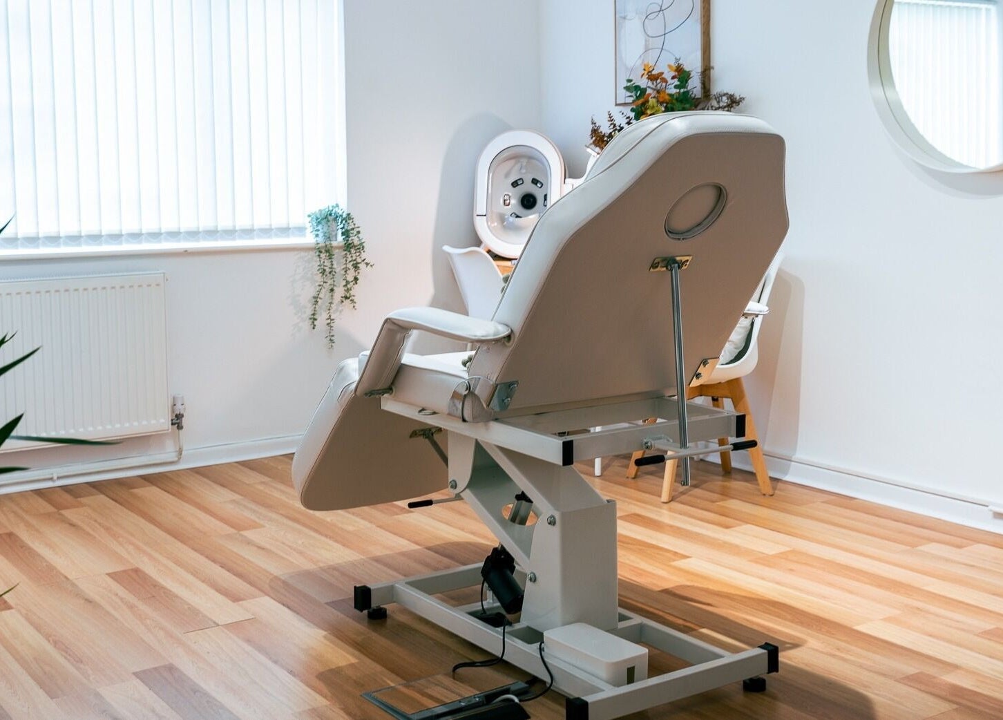 A serene treatment room at Gower Skin Aesthetics, Kittle, Wales, GB featuring a modern adjustable chair.