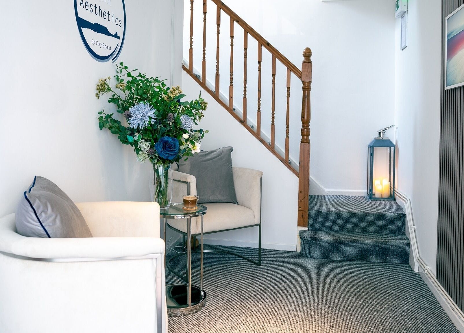 Elegant waiting area at Gower Skin Aesthetics, Kittle, Wales, GB with plush chair and floral decor.