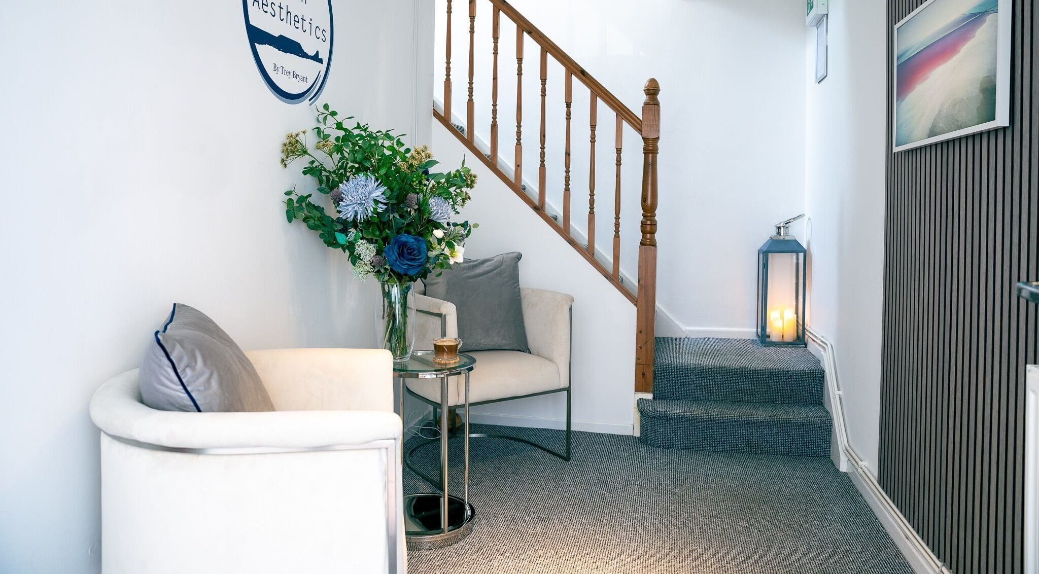 Elegant waiting area at Gower Skin Aesthetics, Kittle, Wales, GB with plush chair and floral decor.