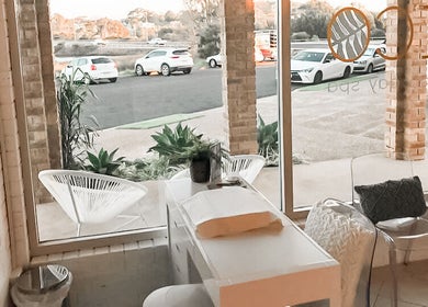 Relaxing seating area at Eco Salon Day Spa, Bermagui, New South Wales, AU, overlooking scenic outdoors.