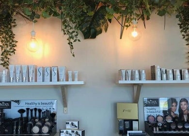 Product shelves at Eco Salon Day Spa, Bermagui, New South Wales, AU adorned with lush greenery.