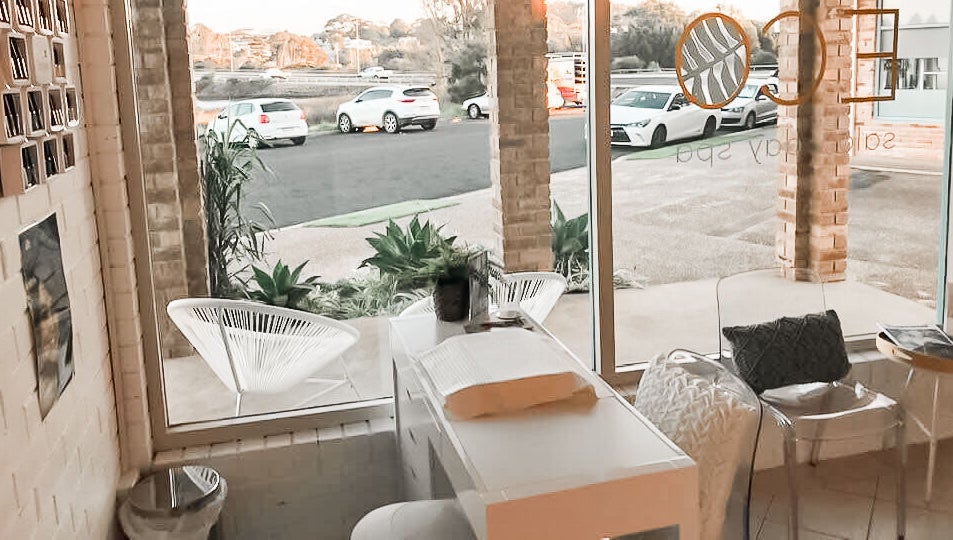 Relaxing seating area at Eco Salon Day Spa in Bermagui, New South Wales, AU with natural light and cozy decor.