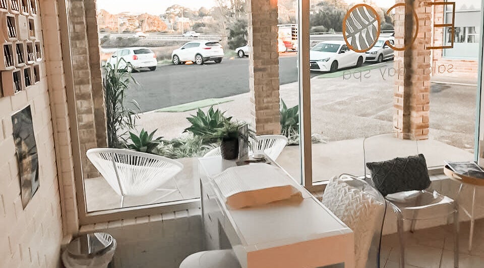 Relaxing seating area at Eco Salon Day Spa in Bermagui, New South Wales, AU with natural light and cozy decor.