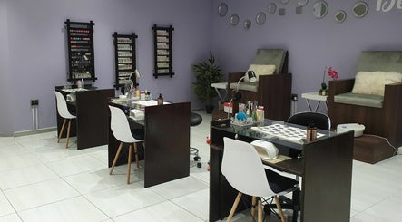 Chic interior of Beaunique Beauty Studio Casino in Welkom, Free State, ZA, featuring nail stations and comfy chairs.