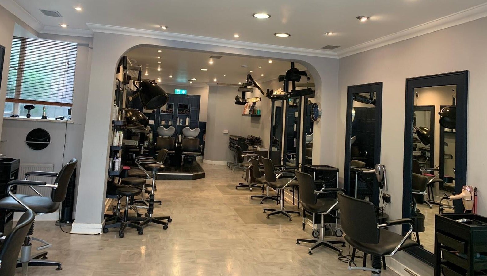 Chic interior of Ethos Blackpool, a beauty salon in Blackpool, England, GB, featuring stylish salon chairs and mirrors.