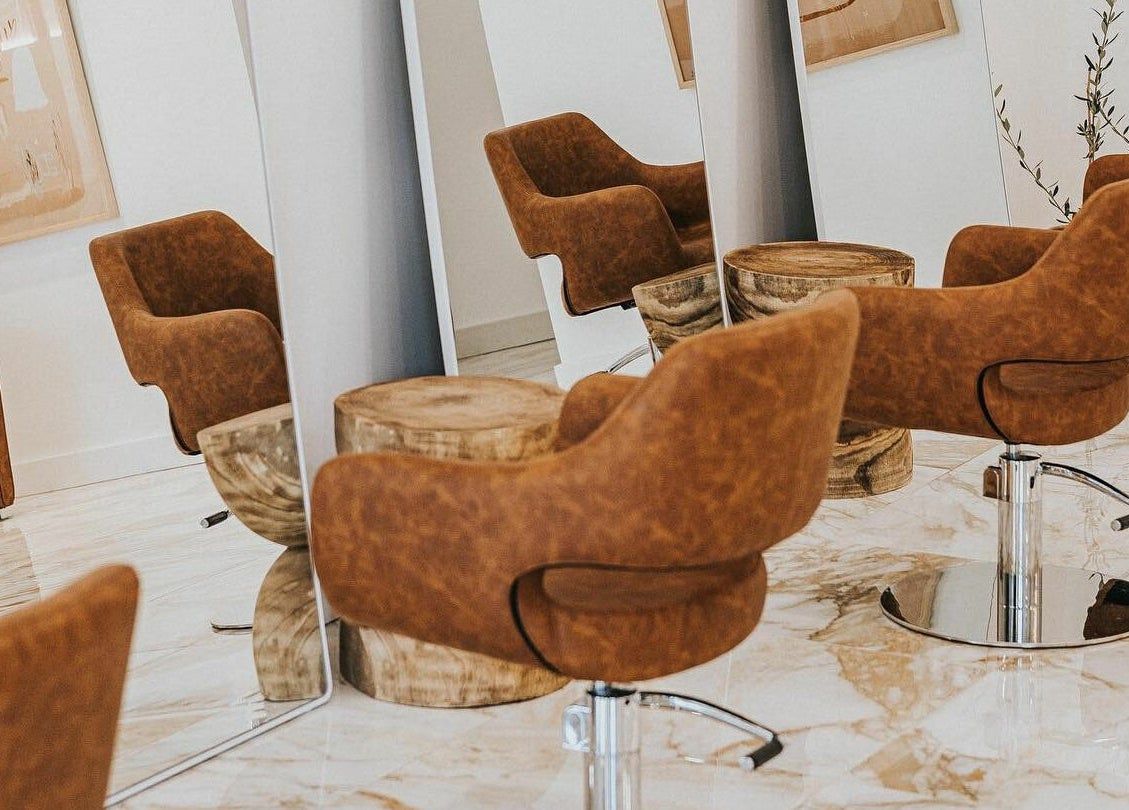 Sleek interior of Blondie Bar Salon in Melbourne, Victoria, AU with stylish brown chairs and mirrors.