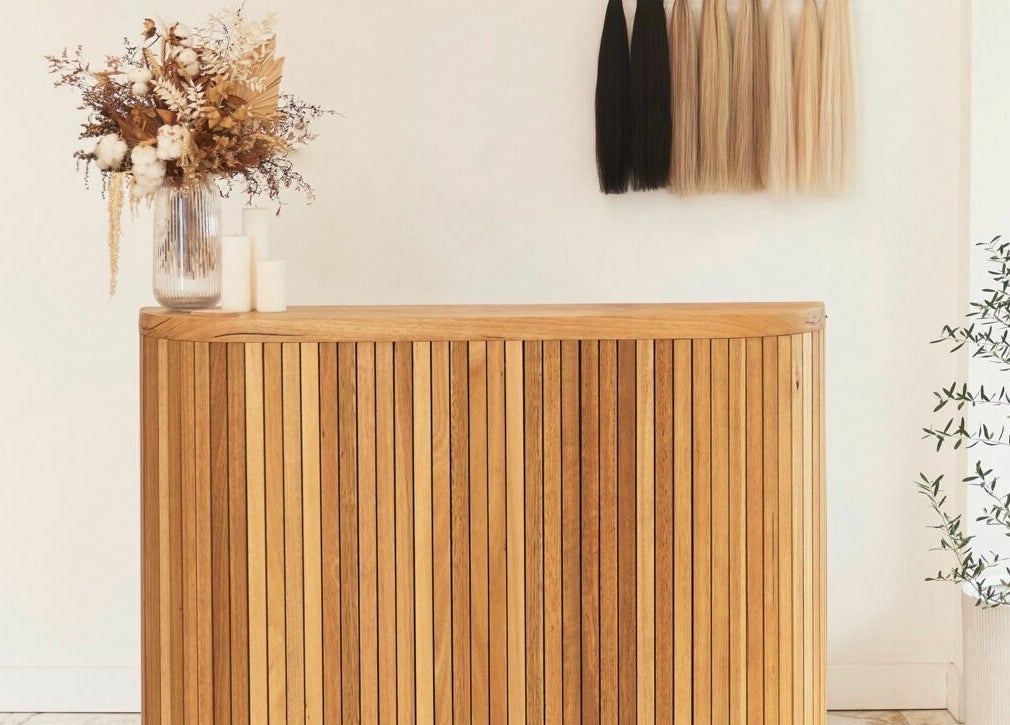 Stylish reception at Blondie Bar Salon, Melbourne, Victoria, AU featuring wood counter and floral decor.