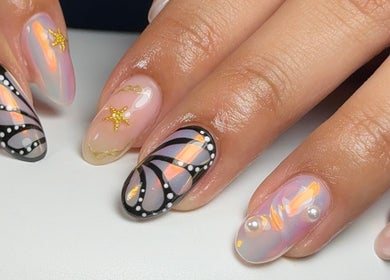 Elegant nail art with butterfly and pearl designs at Solara Beauty, Toronto, Ontario, CA. Perfect for a chic look.